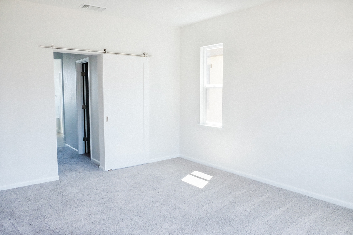 Master bedroom with barn door to walk-in closets and master bathroom