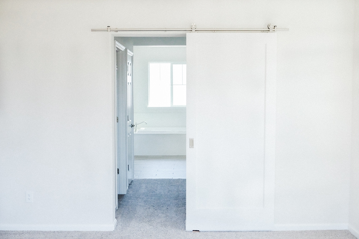 Master bedroom with barn door to walk-in closets and master bathroom